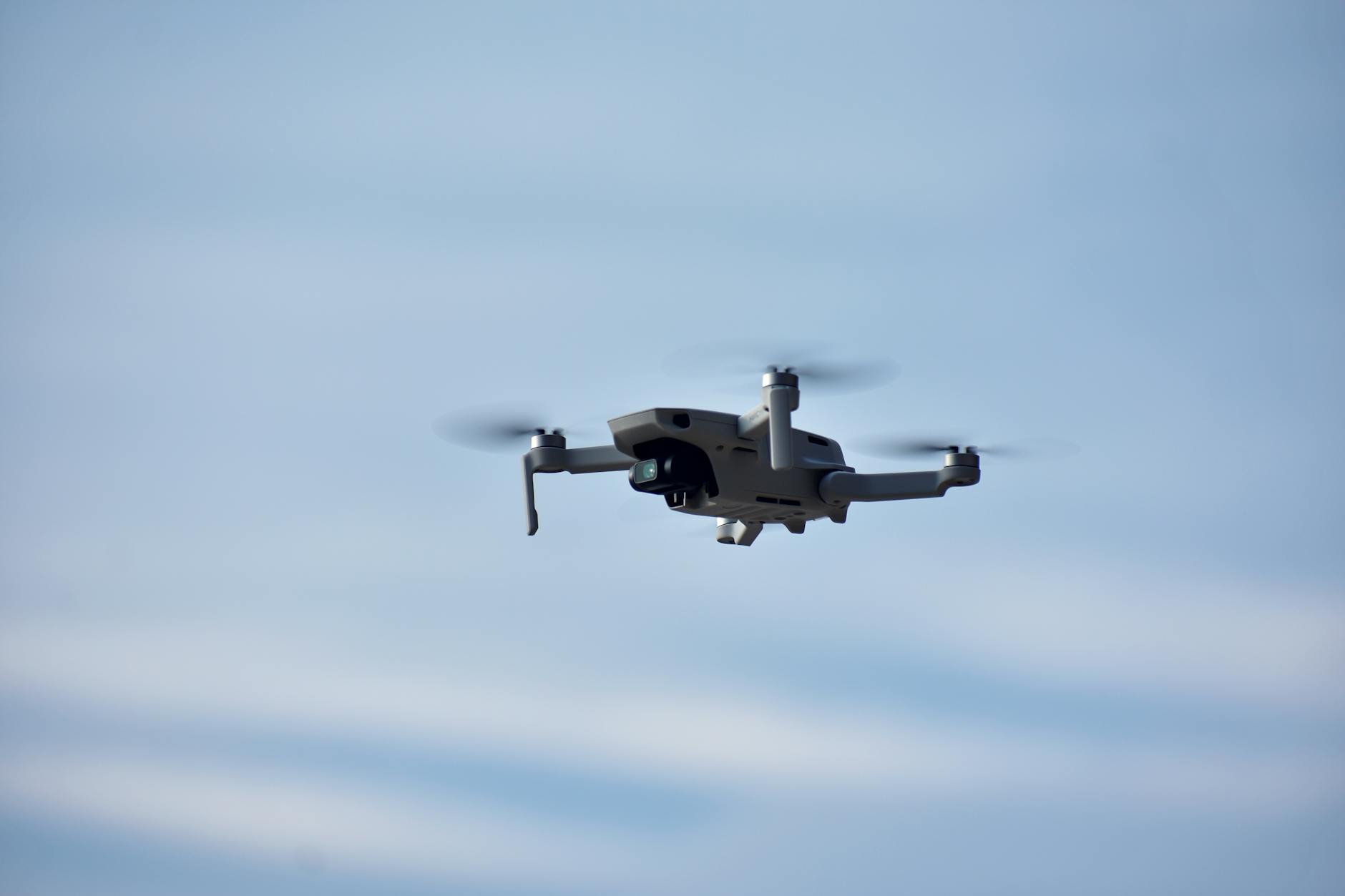 gray and black drone flying in the sky